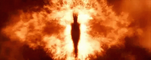 A Close Up Of A Person 'S Eye Surrounded By Flames In A Dark Room . GIF