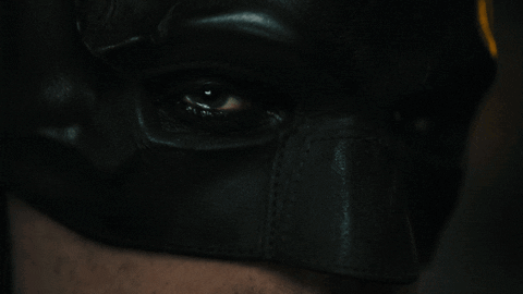 A Close Up Of A Person 'S Eye Wearing A Batman Mask GIF