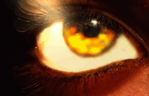 a close up of a person 's eye with a yellow glow in it