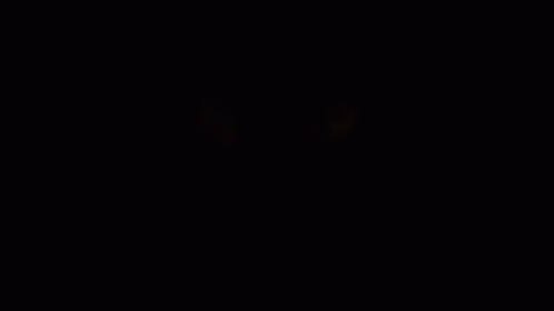 A Close Up Of A Person 'S Eyes Glowing In The Dark GIF