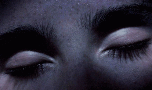 A Close Up Of A Person 'S Eyes With A Purple Background GIF