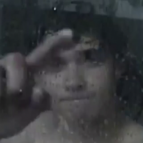A Close Up Of A Person 'S Face Behind A Window With Rain Drops . GIF