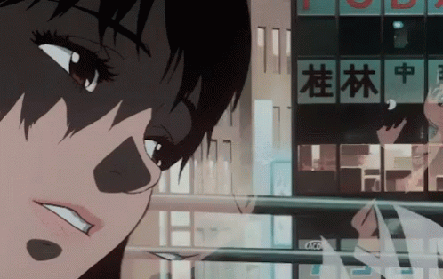 A Close Up Of A Person 'S Face In Front Of A Building That Has Chinese Writing On It GIF