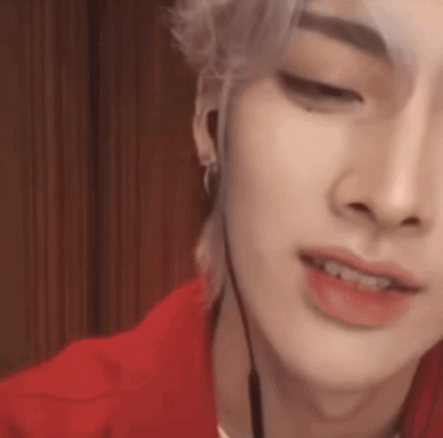 A Close Up Of A Person 'S Face Wearing Headphones And A Red Shirt . GIF