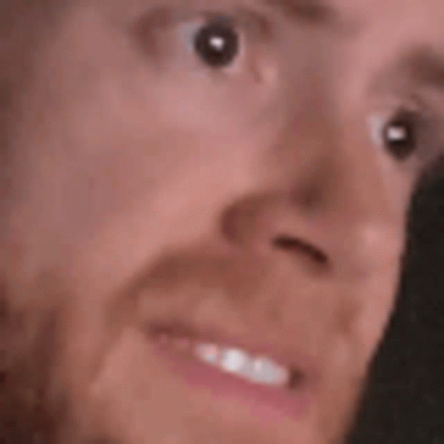 A Close Up Of A Person 'S Face With A Beard And A Smile . GIF