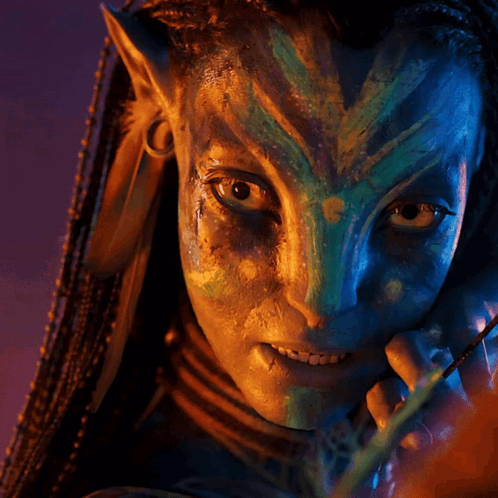 A Close Up Of A Person 'S Face With A Blue And Green Face Paint GIF