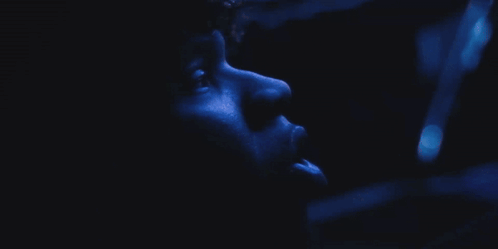 A Close Up Of A Person 'S Face With A Blue Background GIF