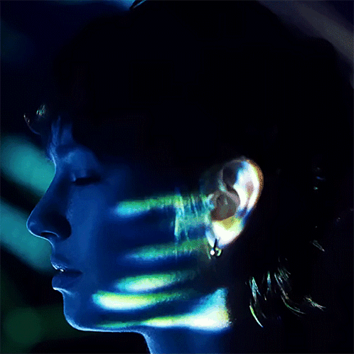 A Close Up Of A Person 'S Face With A Blue Light Shining On It GIF