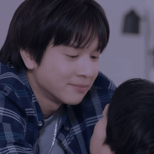 A Close Up Of A Person 'S Face With A Blue Plaid Shirt GIF