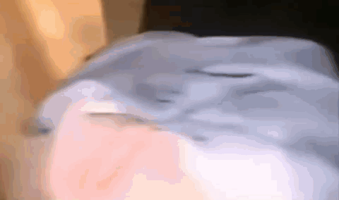 A Close Up Of A Person 'S Face With A Blue Shirt On GIF