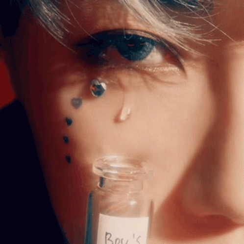 A Close Up Of A Person 'S Face With A Bottle Of Boy 'S On It GIF
