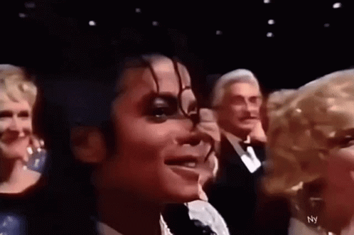 a close up of a person 's face with a group of people behind them .