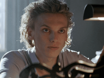 A Close Up Of A Person 'S Face With A Light Behind Them GIF