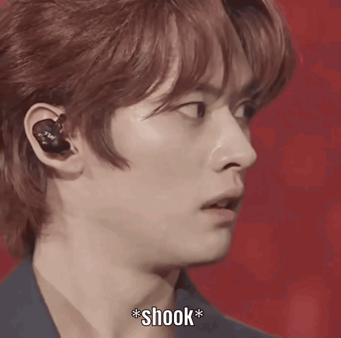 A Close Up Of A Person 'S Face With A Microphone And The Word Shook Below It GIF