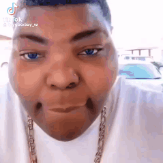 A Close Up Of A Person 'S Face With A Necklace Around Their Neck . GIF