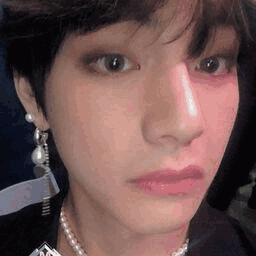 A Close Up Of A Person 'S Face With A Pearl Necklace . GIF