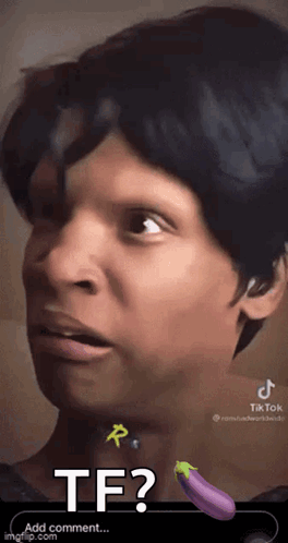 A Close Up Of A Person 'S Face With A Purple Eggplant In The Background . GIF