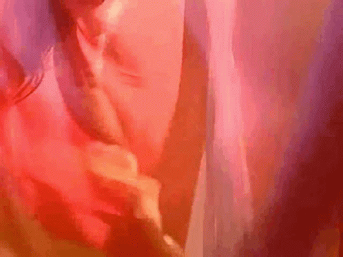 A Close Up Of A Person 'S Face With A Red Background And A Blurred Background . GIF