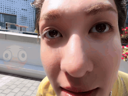 A Close Up Of A Person 'S Face With A Smiley Face Behind It GIF