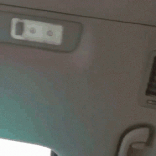 A Close Up Of A Person 'S Face With A White Light On The Ceiling GIF