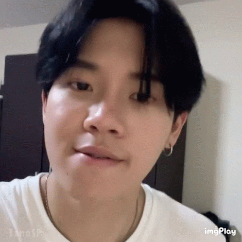 A Close Up Of A Person 'S Face With A White Shirt And Black Hair . GIF