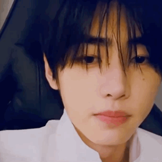 A Close Up Of A Person 'S Face With A White Shirt On And A Black Background . GIF