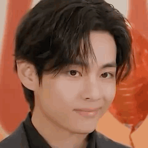 A Close Up Of A Person 'S Face With Balloons In The Background And A Smile On Their Face . GIF