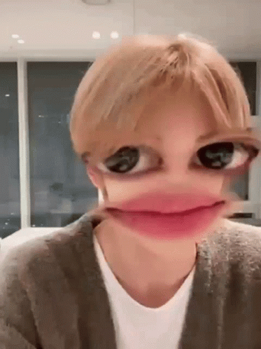 A Close Up Of A Person 'S Face With Big Eyes And A Pink Lip . GIF