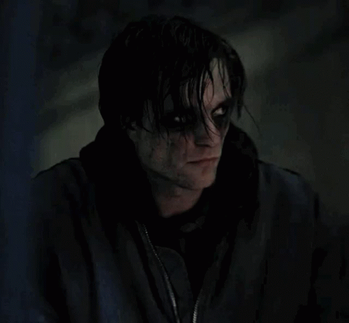 A Close Up Of A Person 'S Face With Black Eyes And A Black Jacket On . GIF