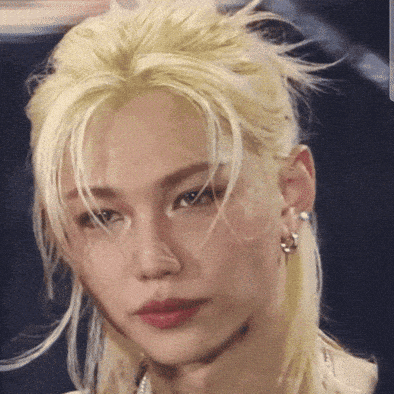 A Close Up Of A Person 'S Face With Blonde Hair And Earrings GIF