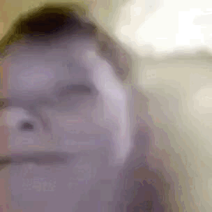 A Close Up Of A Person 'S Face With Glasses And A Blurred Background . GIF