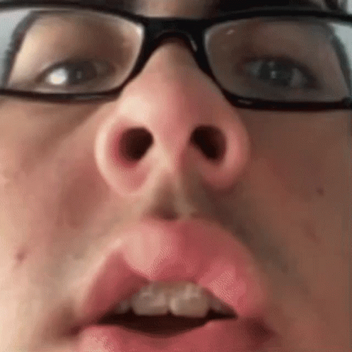 A Close Up Of A Person 'S Face With Glasses And A Pink Lip . GIF