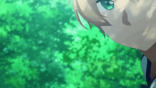 A Close Up Of A Person 'S Face With Green Eyes And Trees In The Background GIF