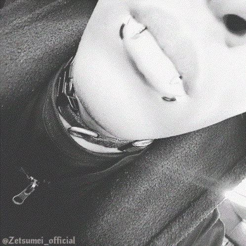 a close up of a person 's face with piercings on their lips and neck .