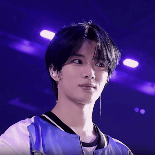 A Close Up Of A Person 'S Face With Purple Lights Behind Him GIF