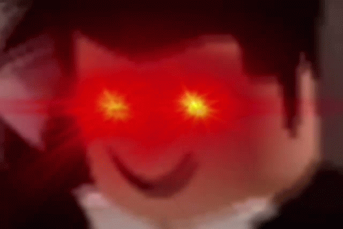 A Close Up Of A Person 'S Face With Red Eyes And A Smile On Their Face . GIF