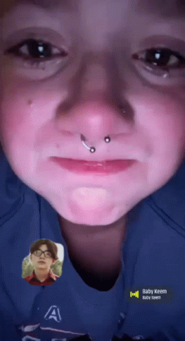A Close Up Of A Person 'S Face With The Name Baby Keem On The Bottom GIF