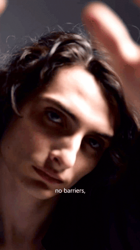 A Close Up Of A Person 'S Face With The Words " No Barriers " Written Below It GIF