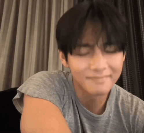 A Close Up Of A Person 'S Face With Their Eyes Closed And A T-Shirt On . GIF