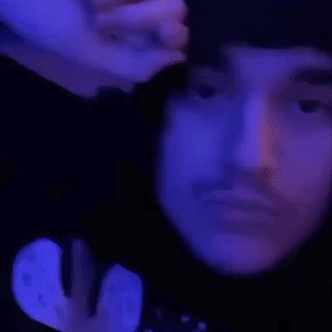 A Close Up Of A Person 'S Face With Their Eyes Closed And Their Hand On Their Forehead . GIF