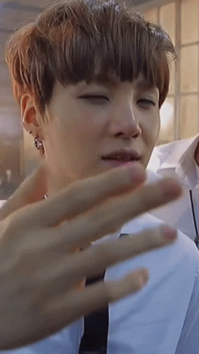 A Close Up Of A Person 'S Face With Their Eyes Closed And Their Hand Visible . GIF