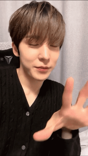 A Close Up Of A Person 'S Face With Their Eyes Closed And Their Hands Outstretched GIF