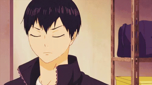 A Close Up Of A Person 'S Face With Their Eyes Closed In Front Of A Shelf . GIF
