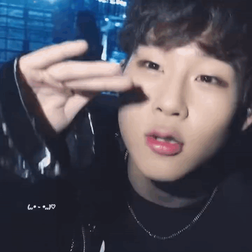 A Close Up Of A Person 'S Face With Their Finger In Their Nose . GIF