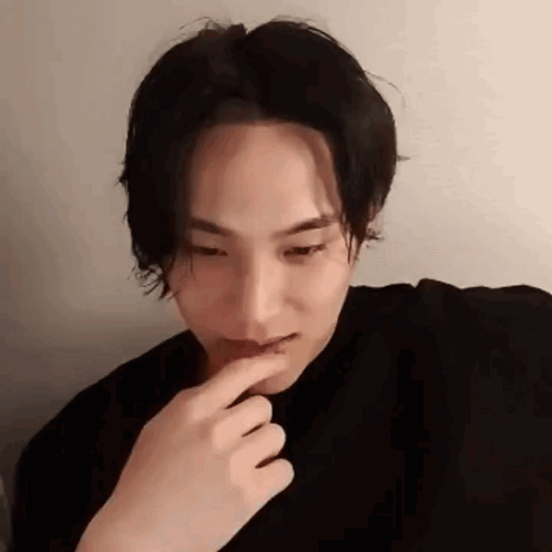 A Close Up Of A Person 'S Face With Their Finger On Their Mouth . GIF