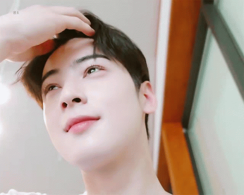 A Close Up Of A Person 'S Face With Their Hand On Their Head . GIF