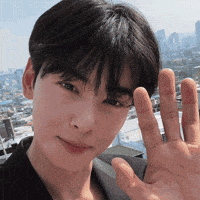 A Close Up Of A Person 'S Face With Their Hand Up In The Air . GIF