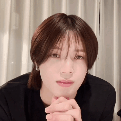 A Close Up Of A Person 'S Face With Their Hands Folded In Front Of Their Face GIF