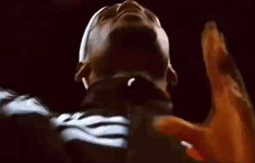 a close up of a person 's face with their hands up in the air .