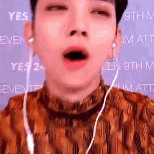 A Close Up Of A Person 'S Face With Their Mouth Open And Earphones . GIF